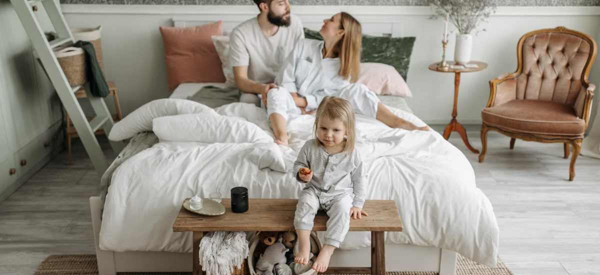A young family enjoying a peaceful morning in their stylish bedroom setting.