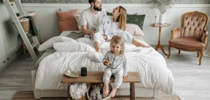 A young family enjoying a peaceful morning in their stylish bedroom setting.