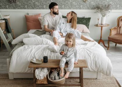 A young family enjoying a peaceful morning in their stylish bedroom setting.